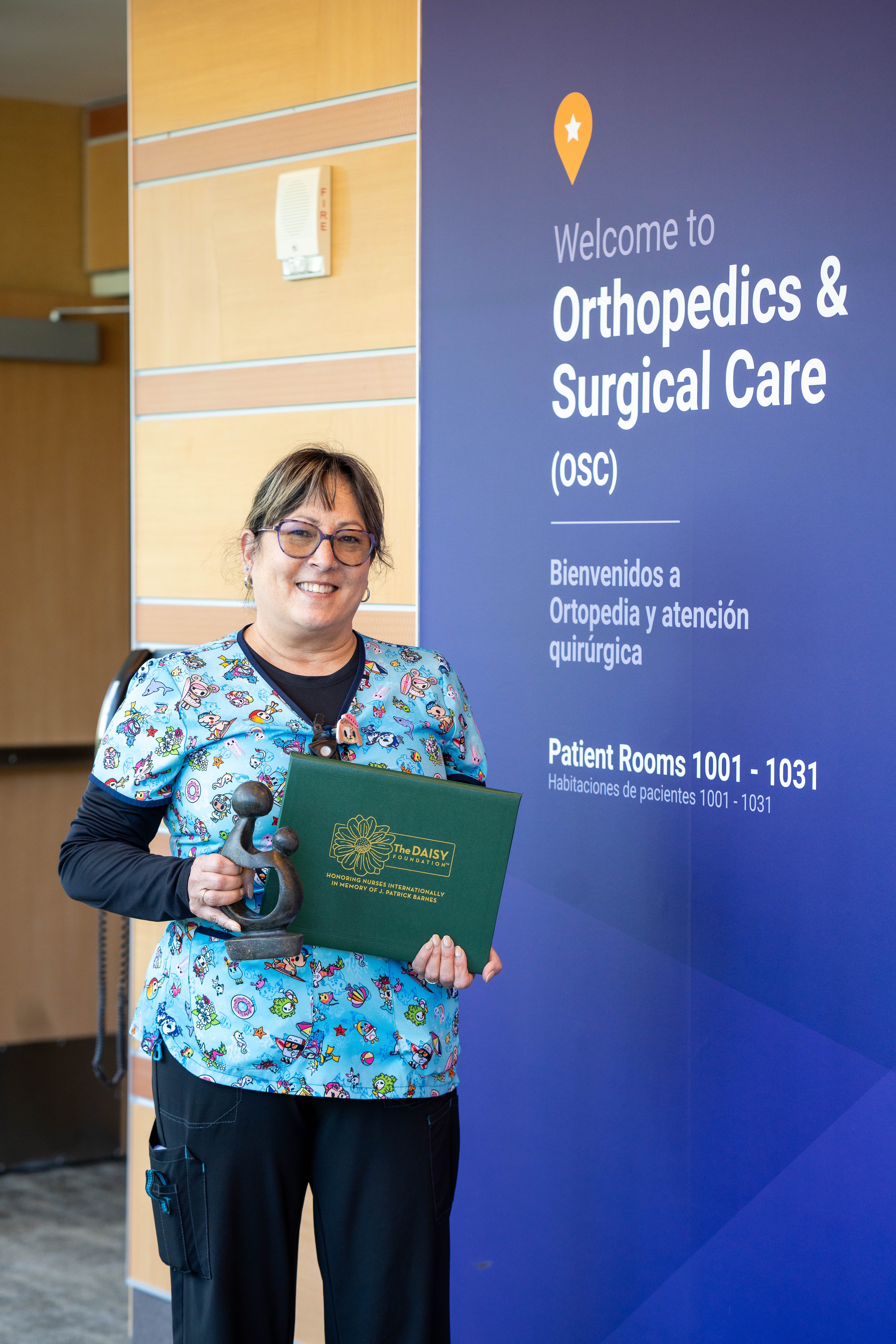 Denise Petty, RN, sostiene el premio DAISY Award y la escultura The Healer's Touch.