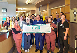 group of healthcare employees holding a banner in a hospital area