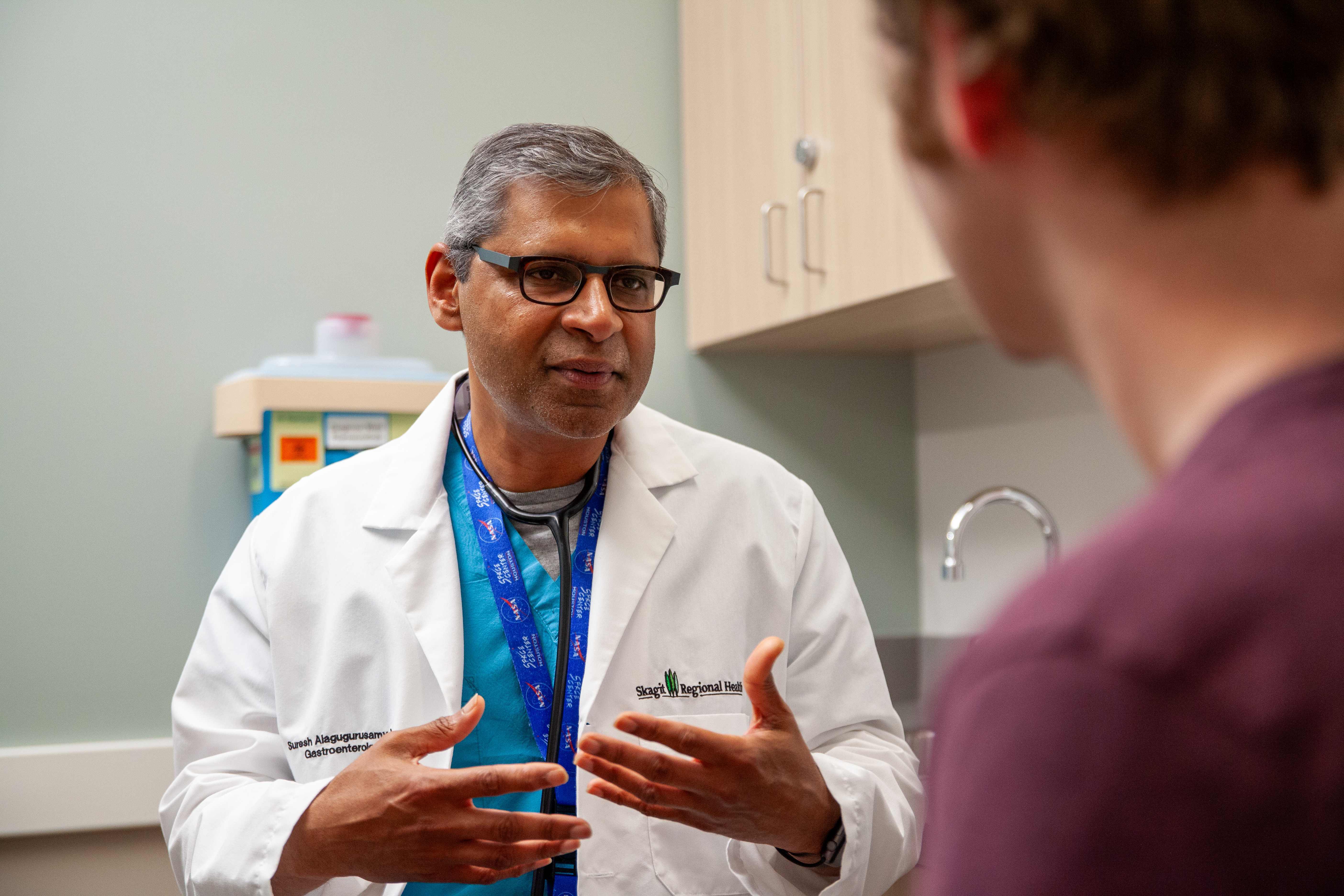 Un médico habla con un paciente en una sala de examen