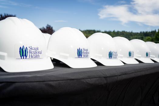 Mesa negra con varios cascos blancos con el logotipo de Skagit Regional Health.
