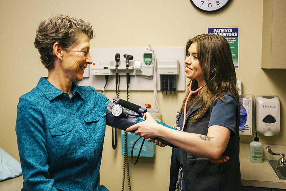Skagit Regional Health nurse taking blood pressure of patient at clinic .