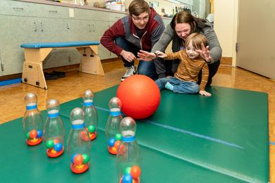 Theo juega con sus padres en terapia infantil