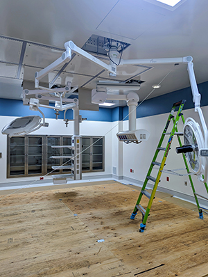Operating room under construction with booms and lighting being installed.