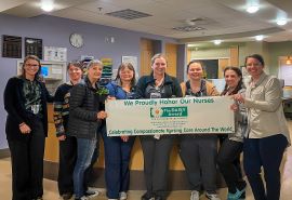 Equipo de enfermería sostiene el cartel del premio DAISY Award.