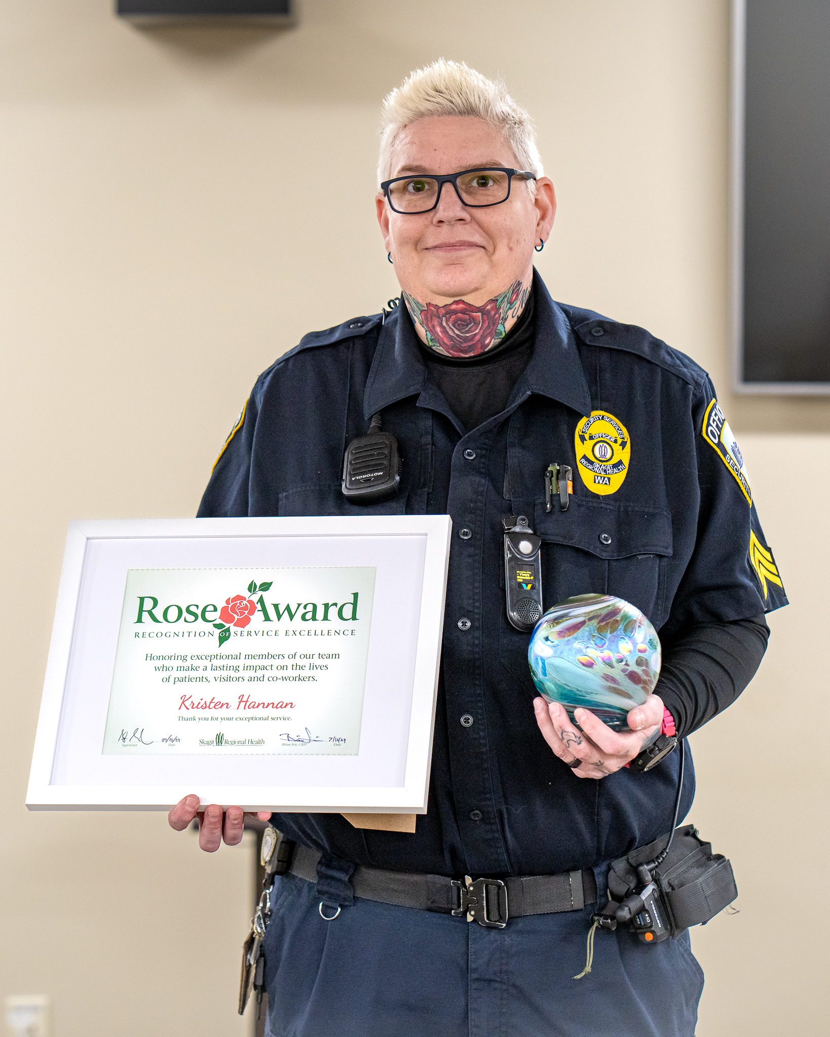 Kristen Hannan holds Rose Award certificate and award