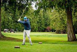 Un golfista haciendo un swing con el palo en un campo de golf