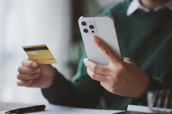 Person holding credit card and mobile device