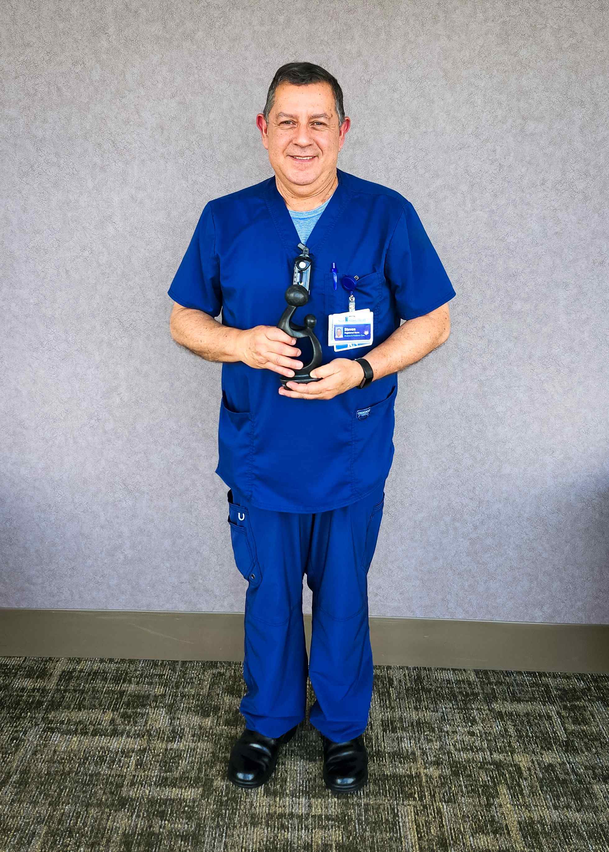 Hombre con ambo sosteniendo el premio recibido.