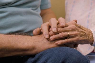 Elderly couple holding hands