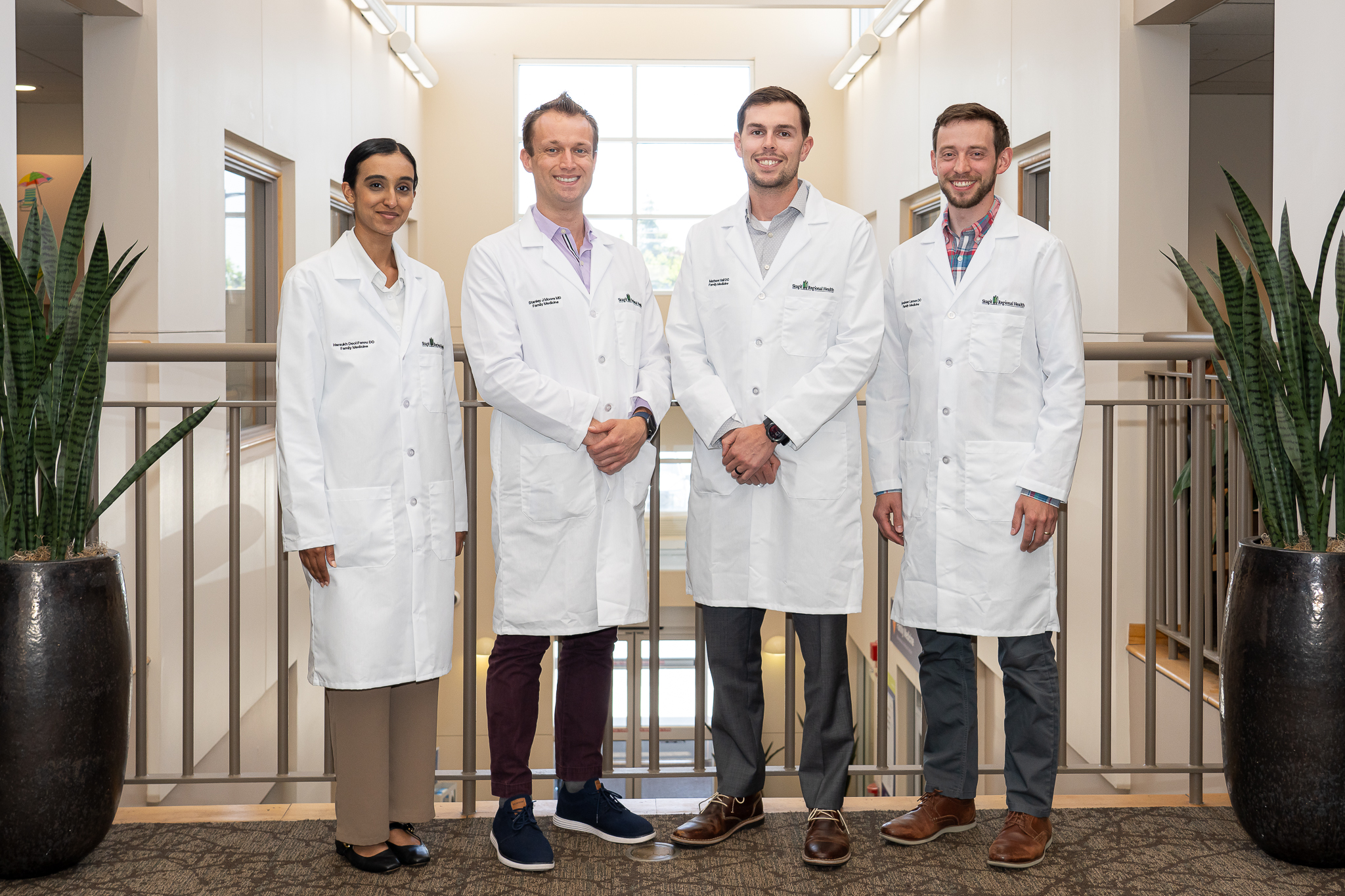Four residents in white coats stand shoulder to shoulder.