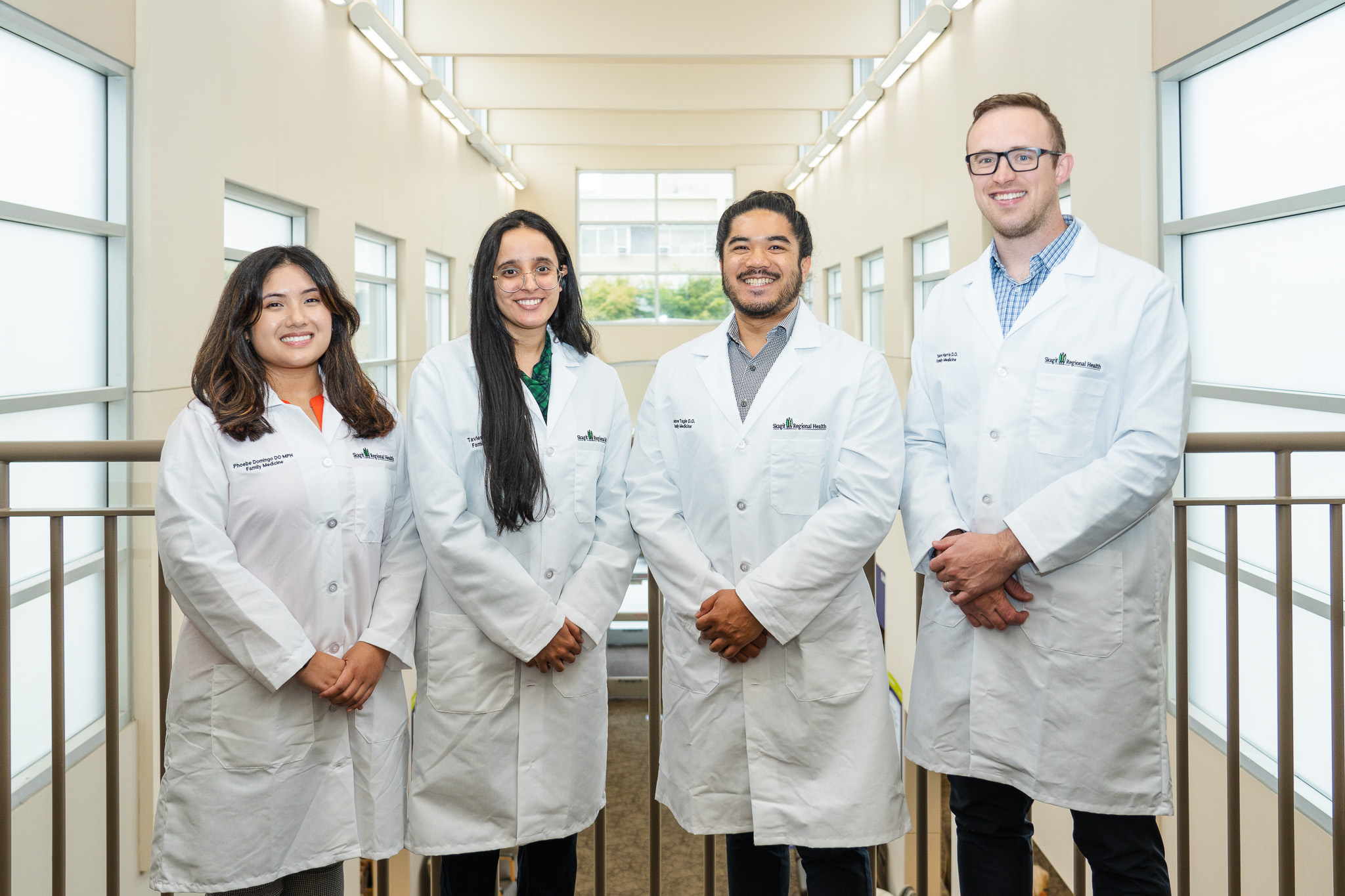 Dos mujeres y dos hombres con batas blancas de médico.