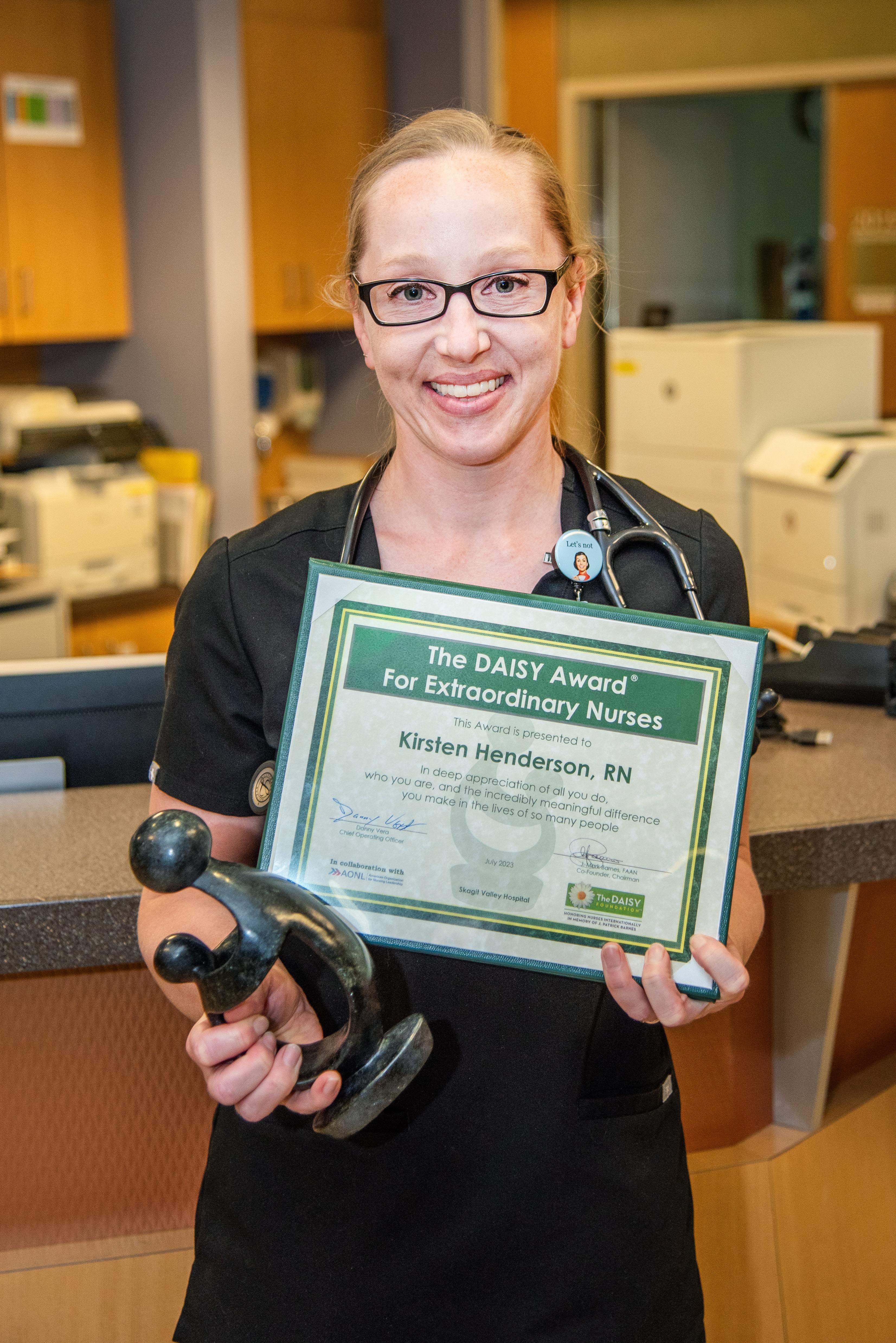 Nurses poses with DAISY Award certificate.