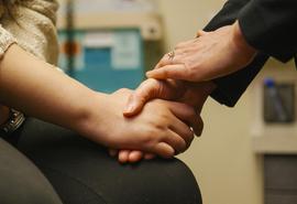 médico sosteniendo la mano de un paciente