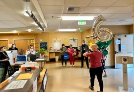 El personal de Skagit Valley Hospital rodea a Emily y la aplaude mientras celebra su última quimioterapia.