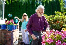 Pareja en su jardín regando las plantas