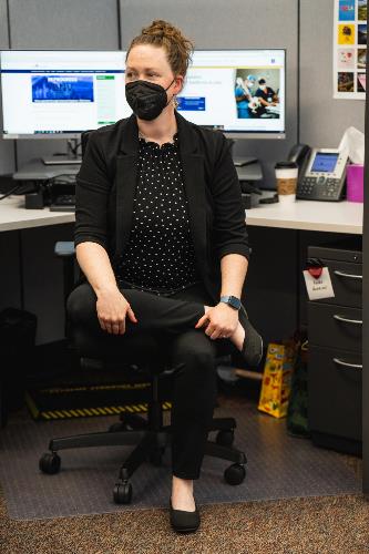 employee at desk with one leg crossed