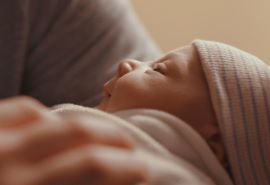 Rostro de un bebé recién nacido concentrado en la persona que lo sostiene