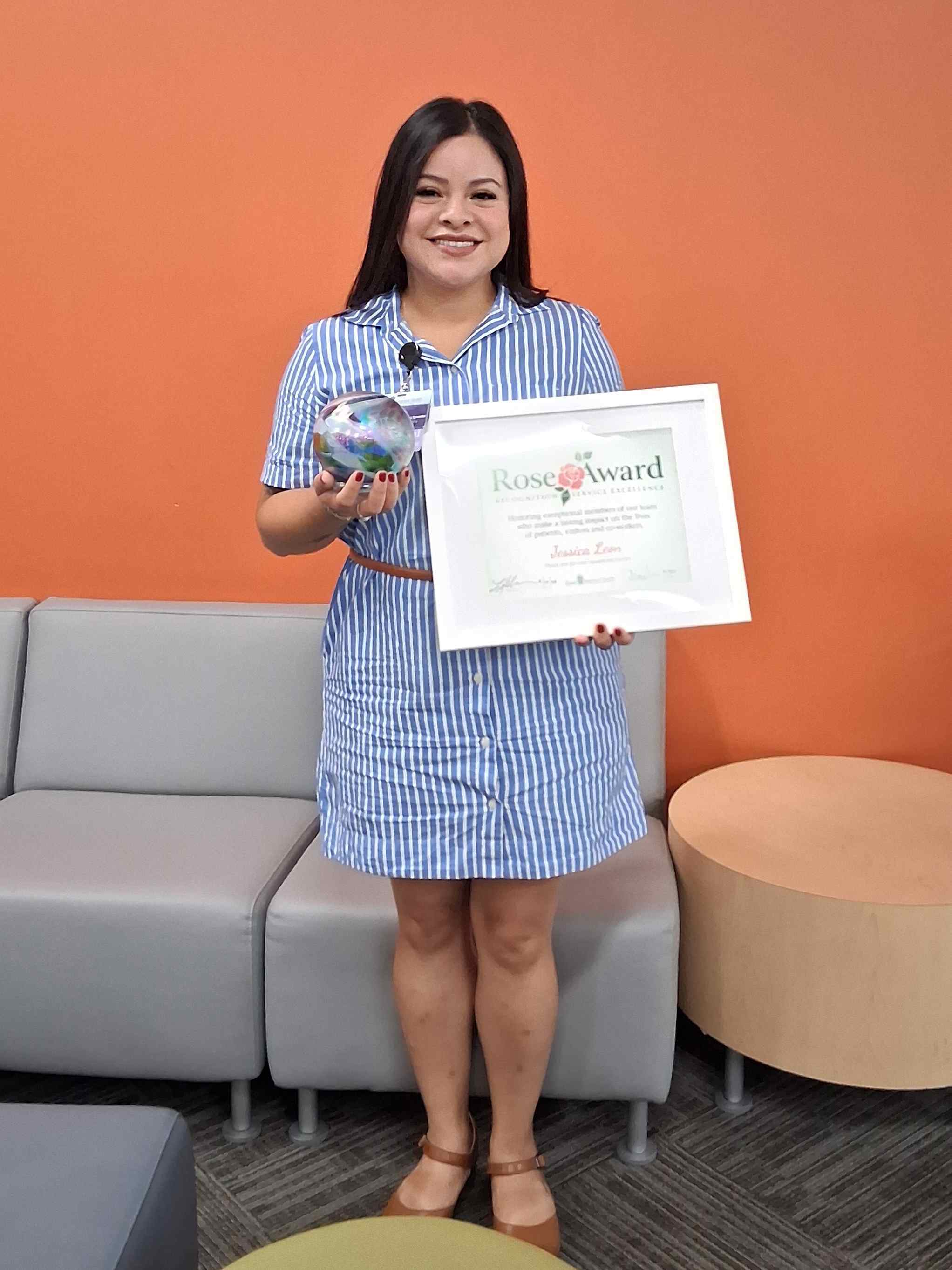 Una mujer sosteniendo un premio, sonriendo