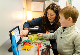 Una mujer y un niño jugando con juguete en una mesa
