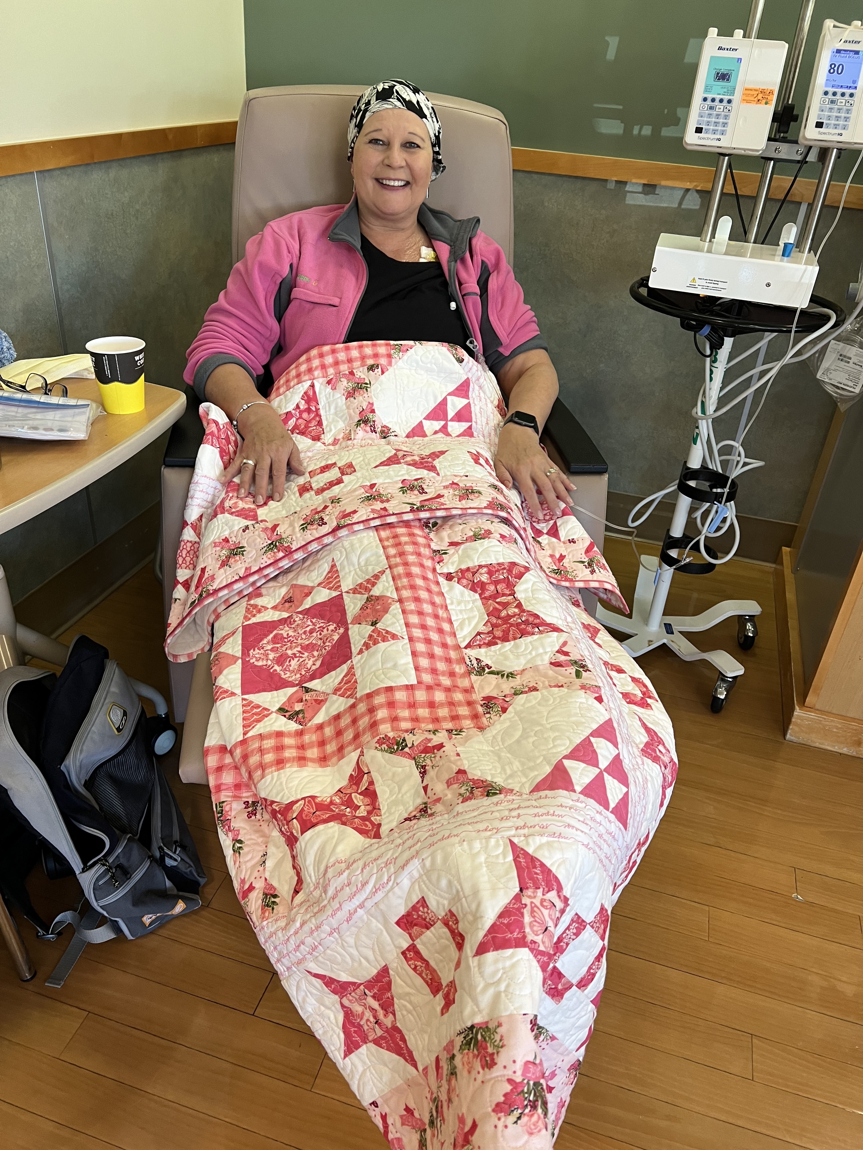 Patient sits in chair under quilt while receiving medical treatment
