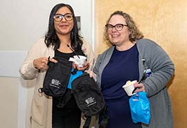 Dos mujeres sosteniendo bolsas y sonriendo