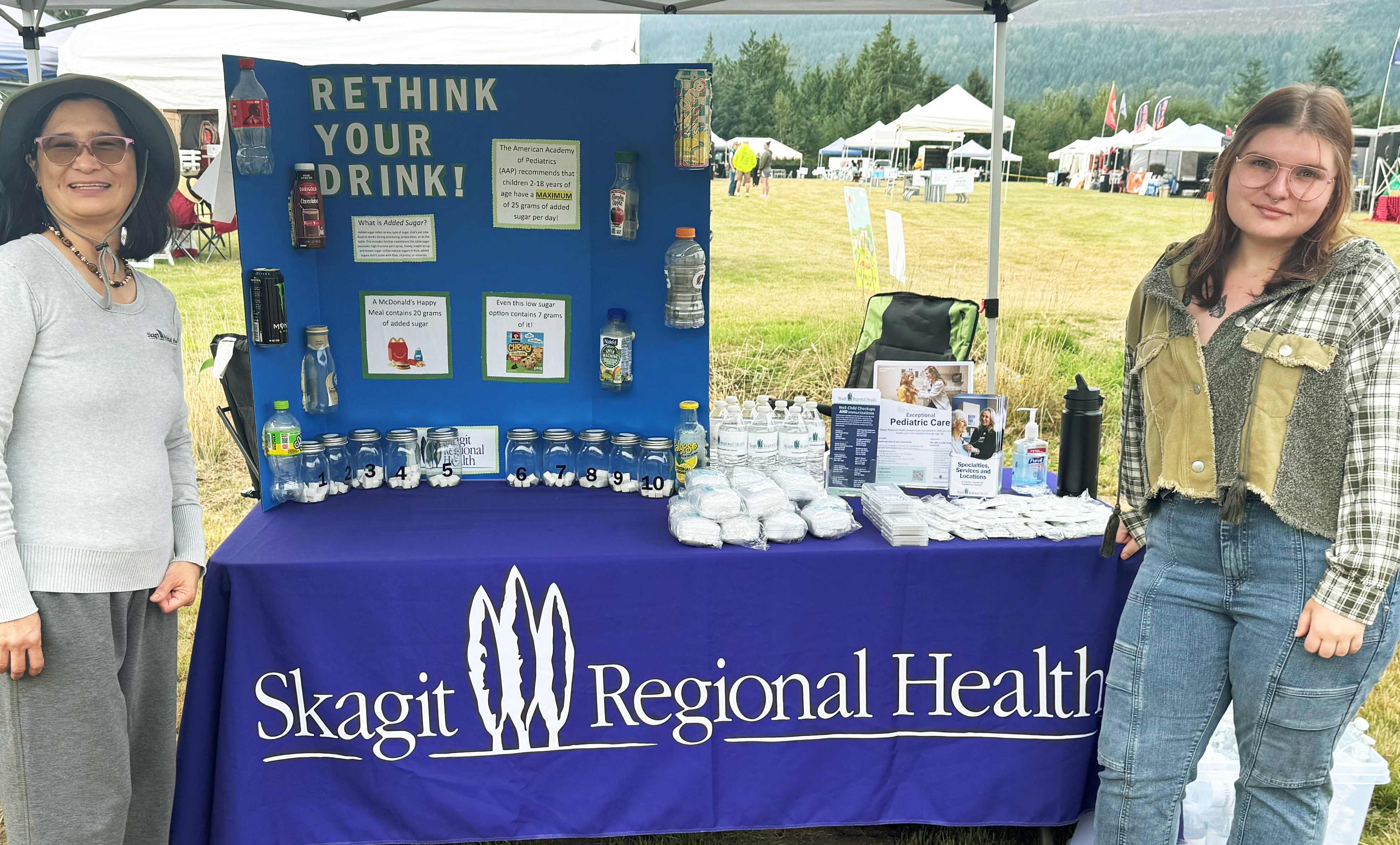 Dos mujeres en un stand promocional al aire libre