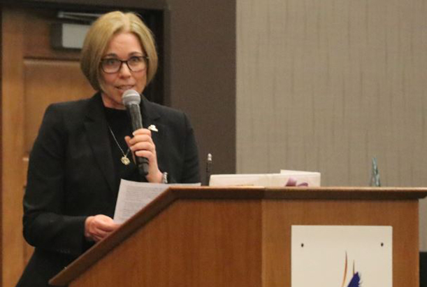 Tamara Cesena gives speech at podium.