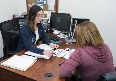 SRH financial services employee explaining paperwork to a patient.
