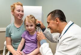 Madre e hija con el médico en un consultorio