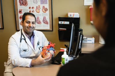 Proveedor muestra a un paciente la maqueta de un corazón