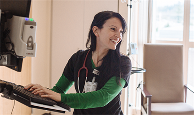 Enfermera sonriente frente a una computadora