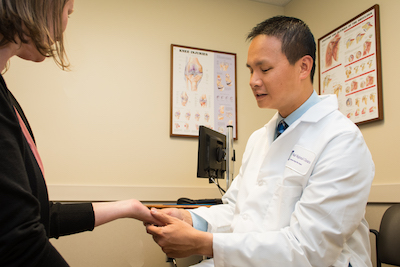 Dr. Dang looking at patient's wrist